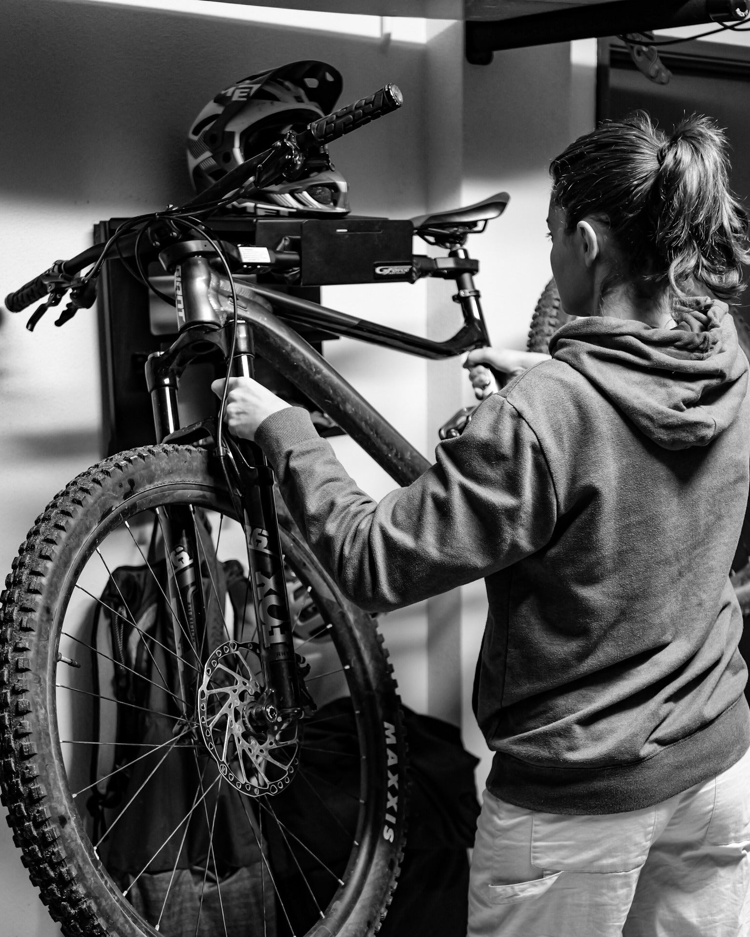 Woman putting a mountain bike on to the wall mounted G-Rack Model 4