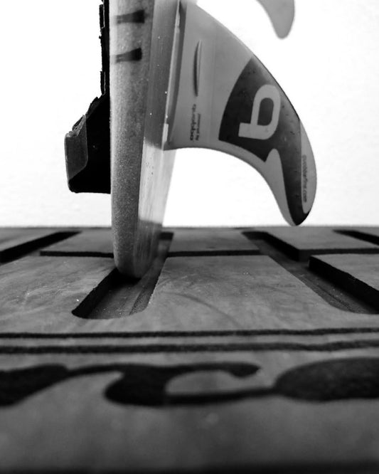 Closeup of a surfboard tail standing on the G-Force Board Mat