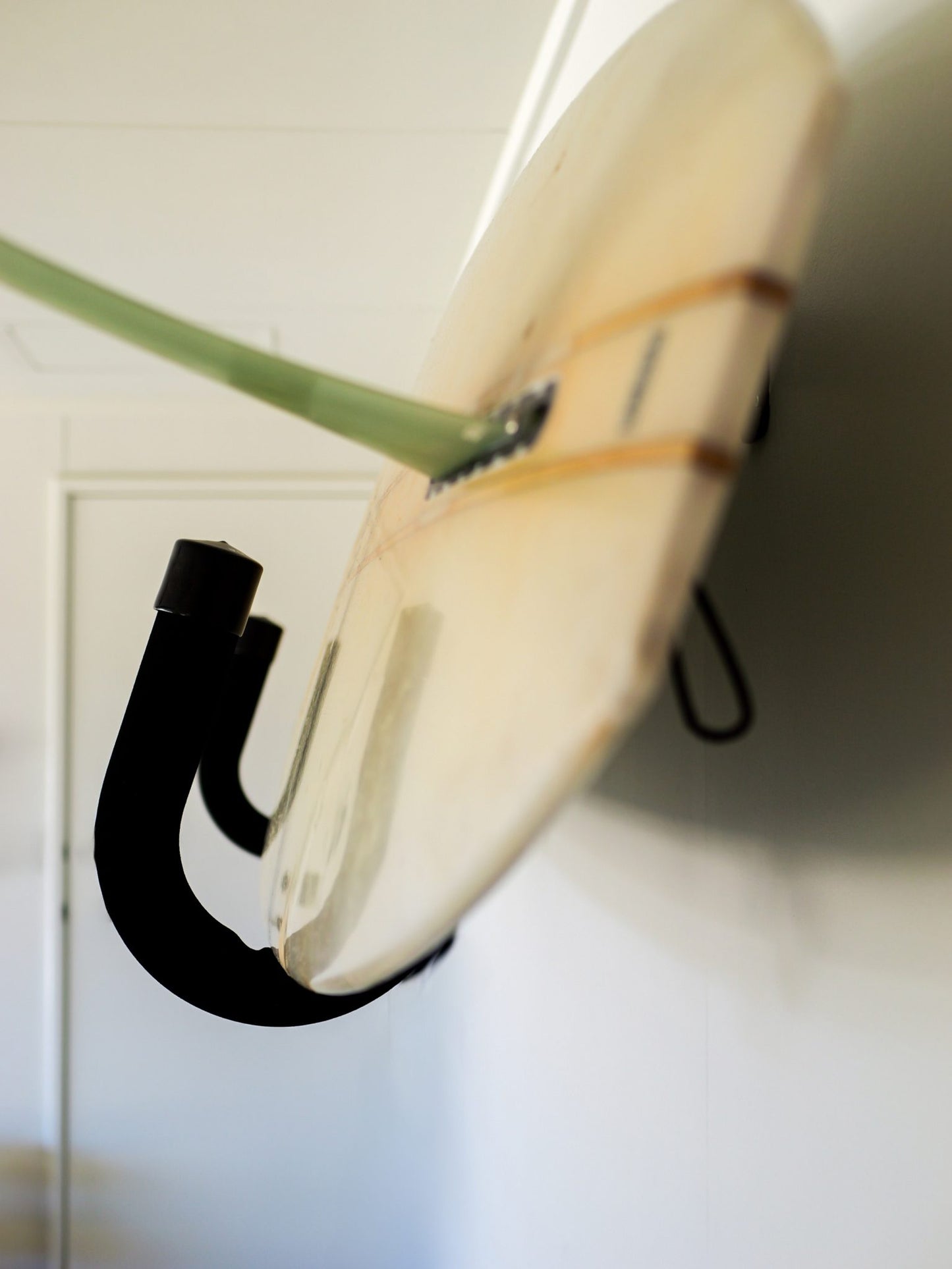 Front view of the GFSUP1 - Wall Mounted Stand Up Paddle Board Rack holding a stand up paddle board with a fin