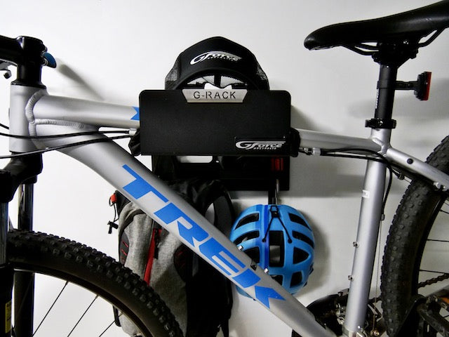 Close-up of the G-Rack Model 3 - Wall Mounted Bike Rack holding a bicycle, helmet, hat and other bike accessories