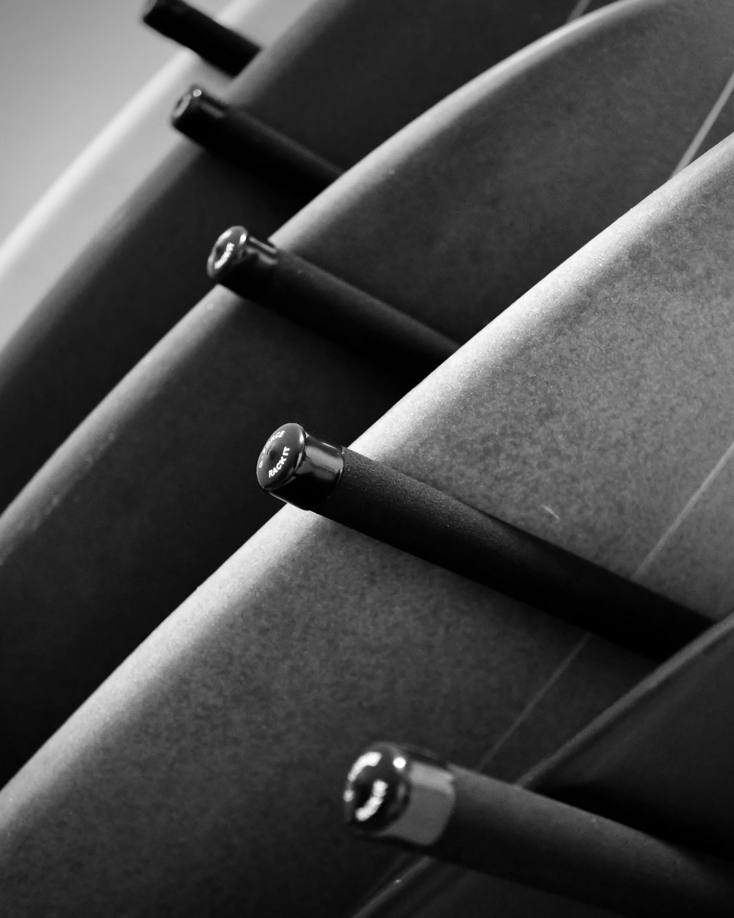Close up of G-Force rack holding multiple surfboards in black and white